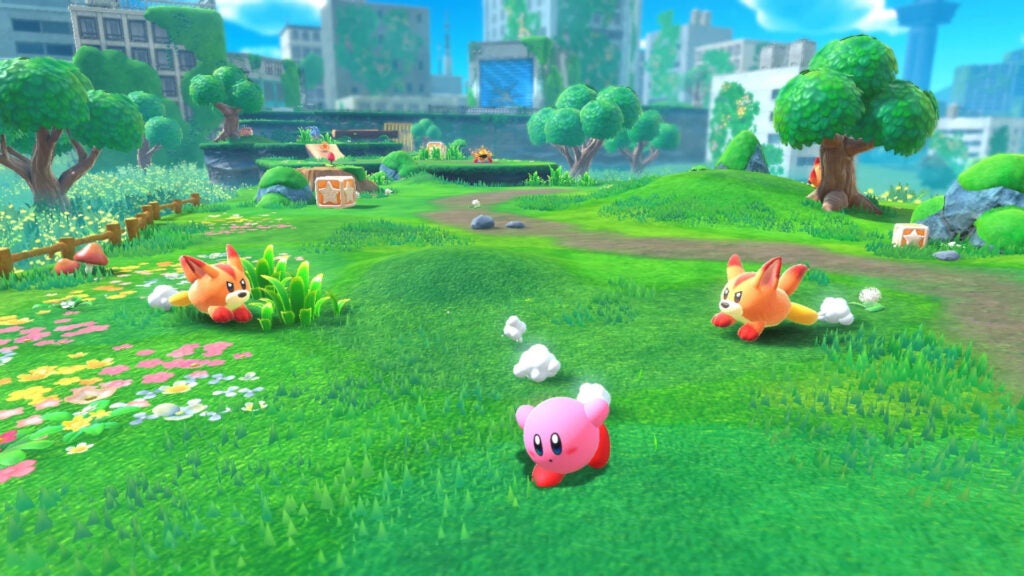 Kirby corriendo por la hierba, más allá de los zorros enemigos