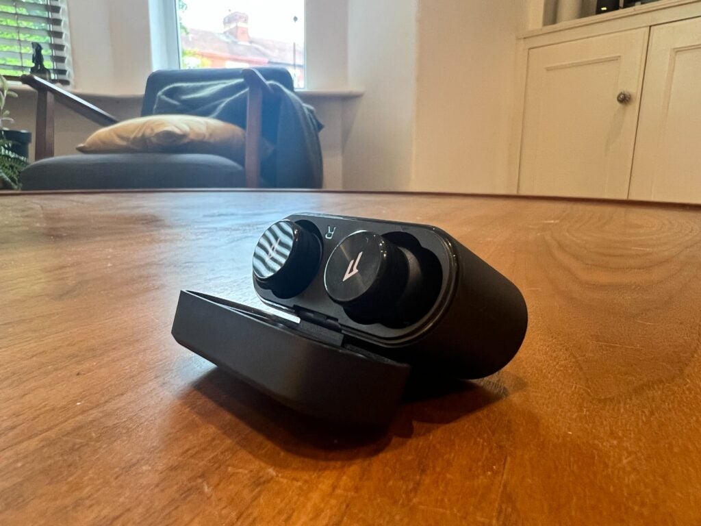El estuche de los PistonBuds Pro se abrió mostrando los auriculares sobre una mesa
