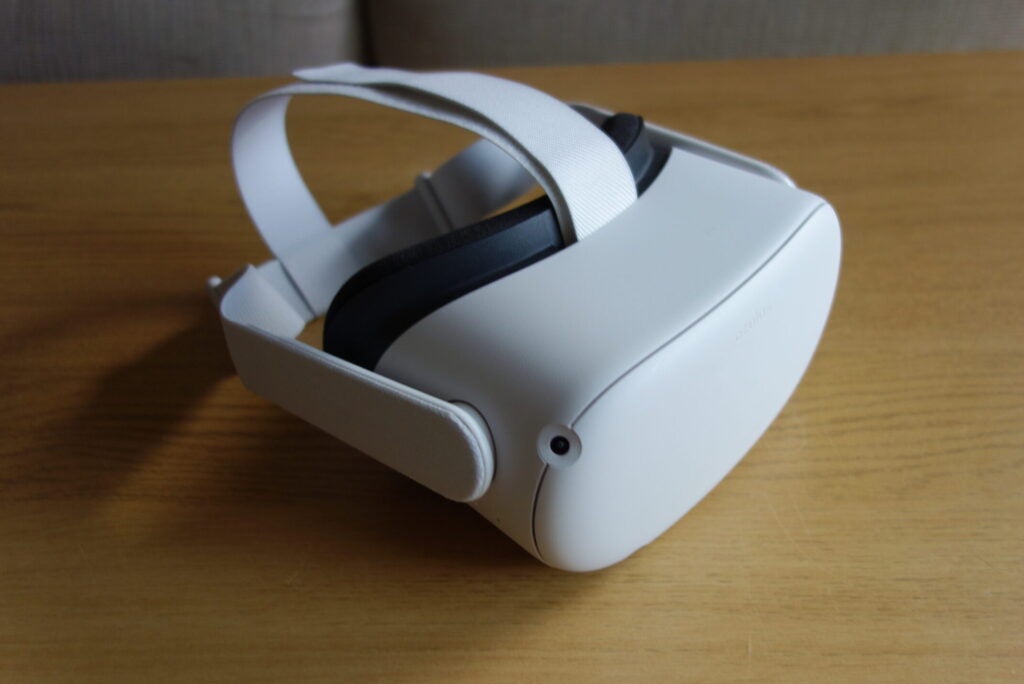 Oculus Quest 2 blanco sobre una mesa de madera, vista trasera izquierda