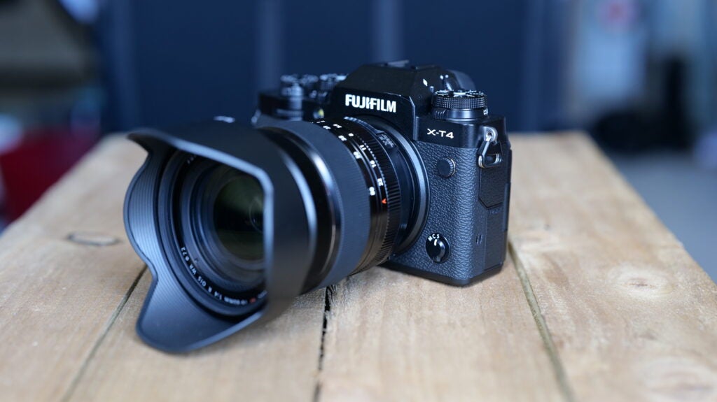 Vista en ángulo recto de una cámara Fujifilm XT4 negra sobre una mesa de madera, vista frontal