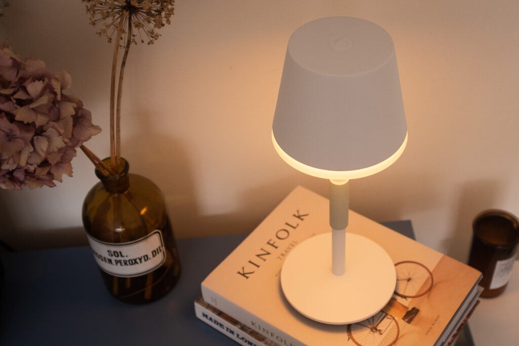 Lámpara de mesa Hue Go sentada sobre libros