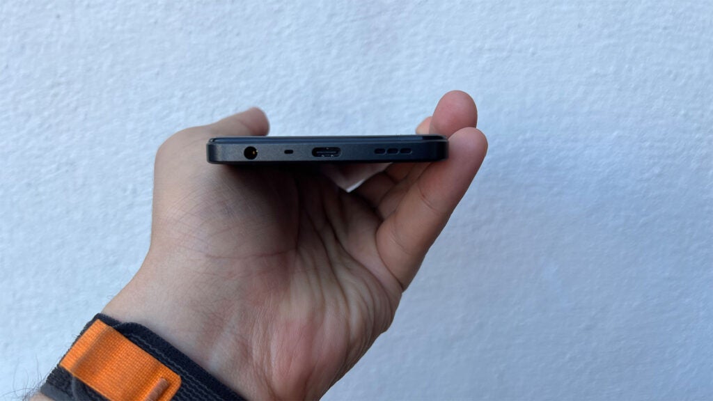 Oppo A78 5G en la mano que muestra el puerto USB-C y el conector para auriculares de 3,5 mm