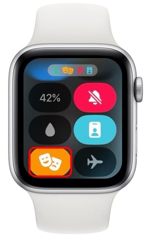 Centro de control del Apple Watch con el ícono del modo teatro (ícono naranja con dos máscaras de teatro) con un círculo rojo