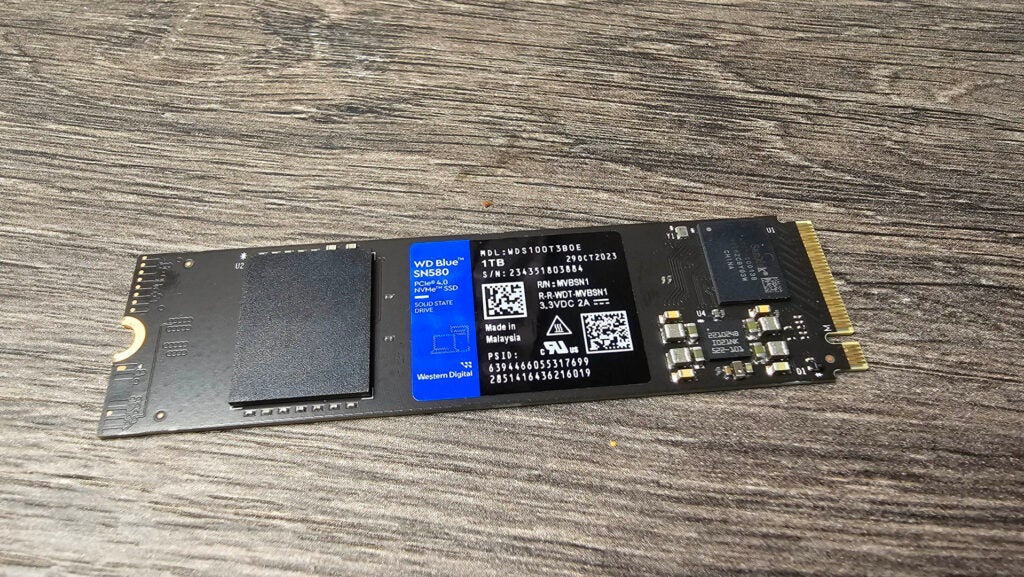 WD Blue SN580 PCie 4.0 M.2 SSD 1TBWD Blue SN580 1TB NVMe SSD sobre superficie de madera.