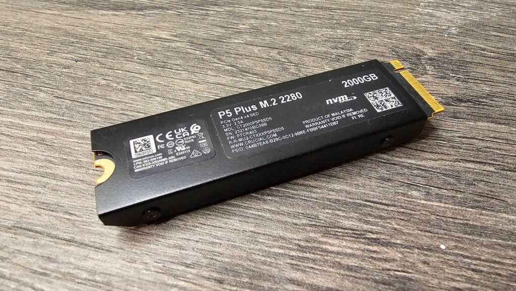 La parte posterior del disipador de calor del SSD P5 Plus M.2 PCIe 4.0 de Crucial Crucial P5 Plus M.2 PCIe 4.0 SSD de 2 TB sobre una superficie de madera.